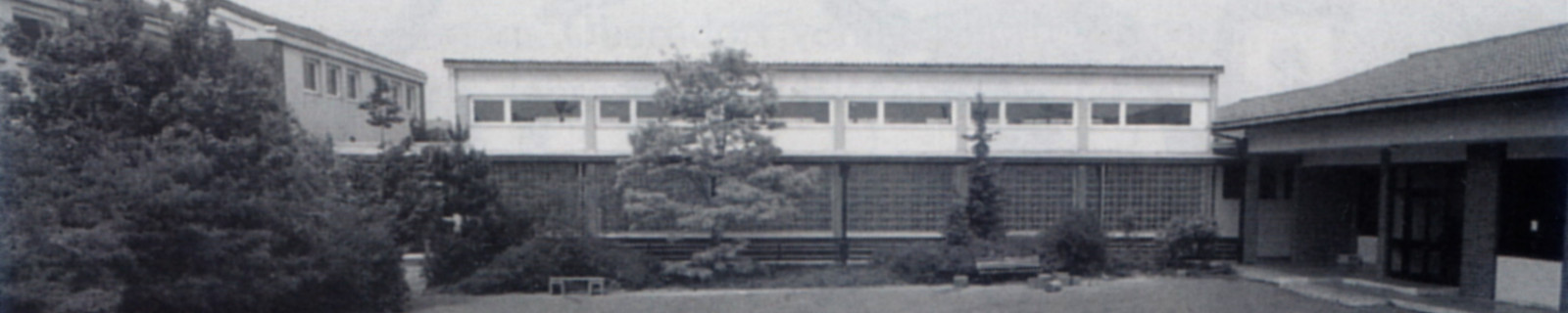 Schulhof mit bemaltem Schachbrett und anderen Mustern, umgeben von Gebäuden.