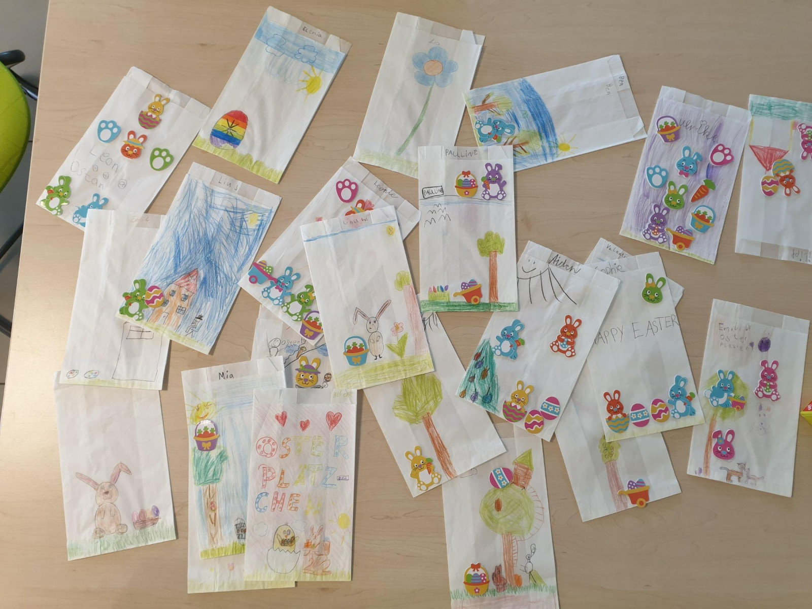 Tisch bedeckt mit Papiertüten, bemalt und dekoriert mit kindlichen Zeichnungen und Stickern.